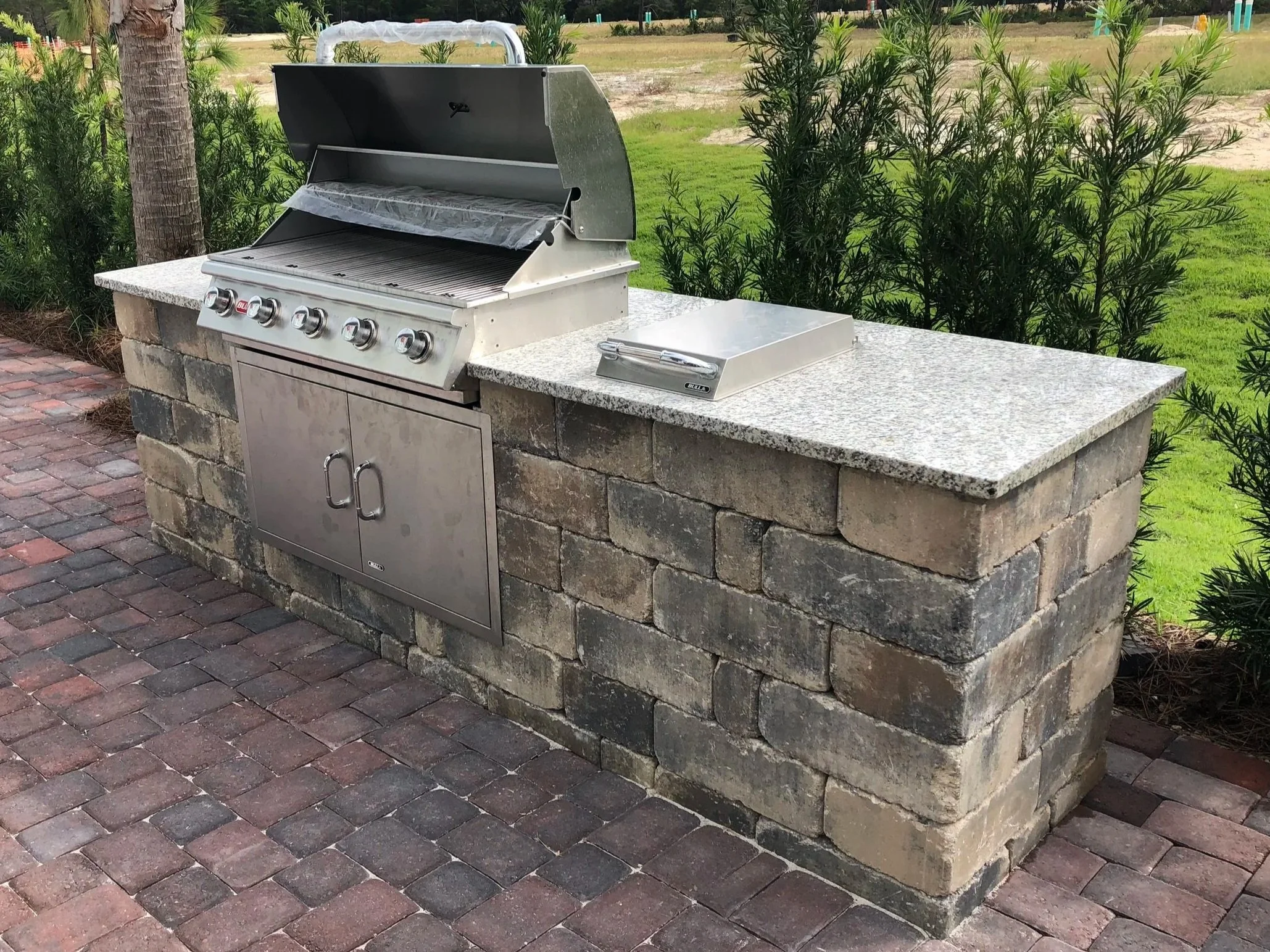 Custom outdoor kitchen with built-in grill and stone counter